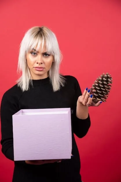 A person holding up an unflattering or unusual clothing item from a SHEIN mystery box, with a slightly disappointed expression. The background is a bedroom, adding a personal touch to the image.