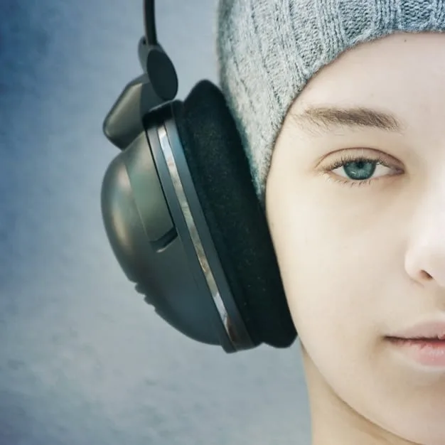 A close-up of the ear cup of a pair of noise-canceling headphones, showing the microphone used for active noise cancellation. The image highlights the technology involved in ANC.