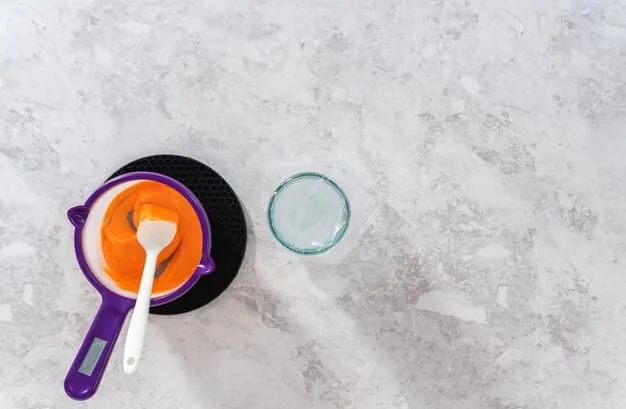 A close-up shot of a textured porcelain tile floor in a modern kitchen, highlighting its scratch resistance with utensils and cookware nearby.