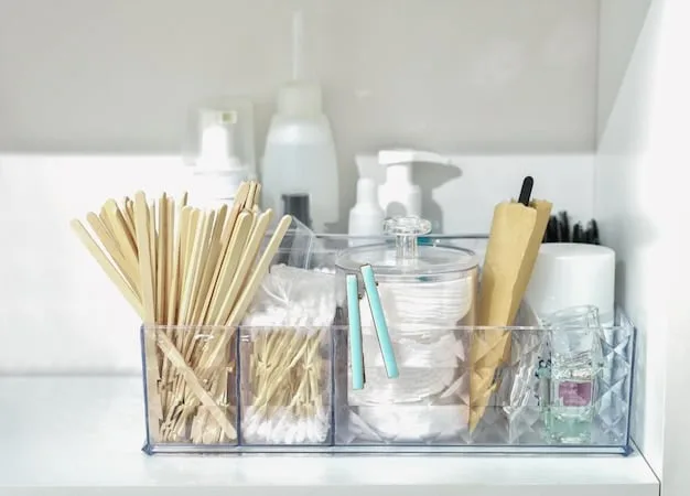 A well-organized bathroom drawer with clear plastic organizers. The organizers contain neatly arranged toiletries, makeup, and hair accessories.
