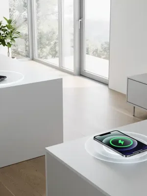 Modern home with devices wirelessly charging on surfaces and over-the-air.